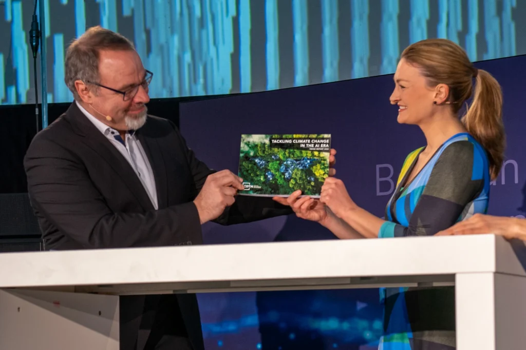 KI-Ratsmitglied Prof. Dietmar Harhoff (links) übergibt der bayerischen Staatsministerin für Digitalisierung Judith Gerlach (rechts) die CDTM-Studie zu KI-gestützten Lösungsansätzen für den Klimaschutz